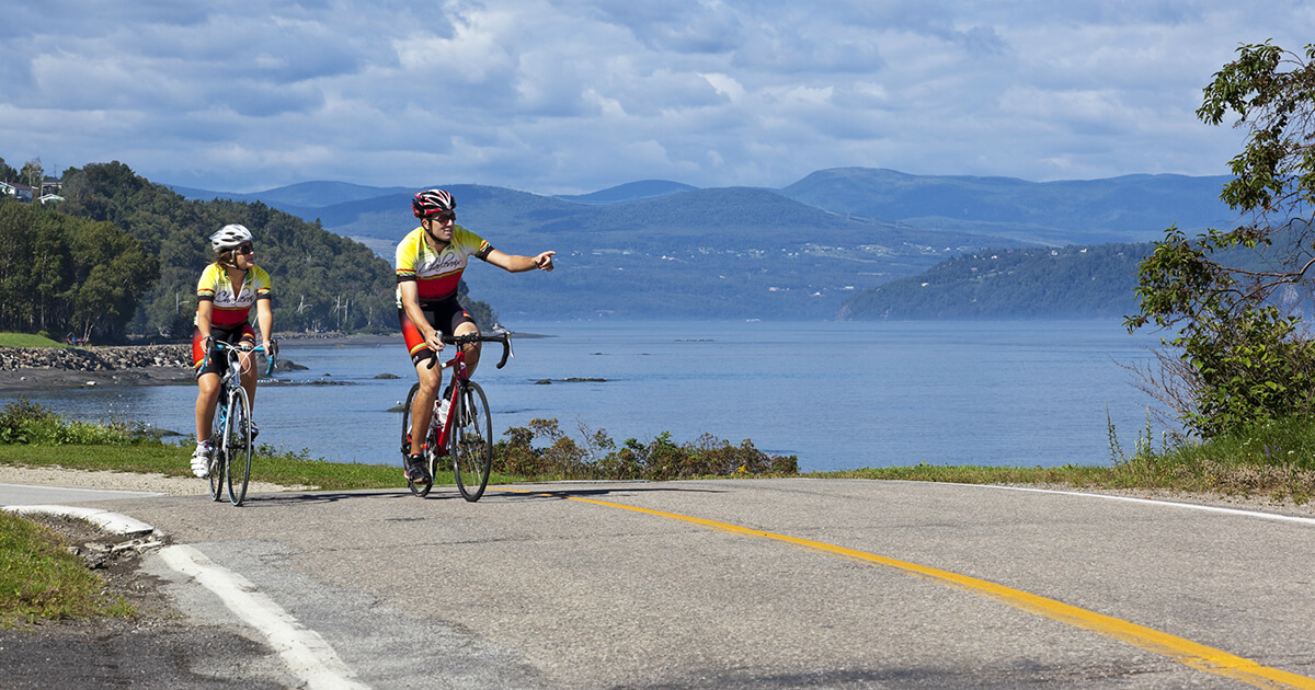 choses à faire dans charlevoix pendant la semaine de la construction 2 personnes faisant du vélo sur une route dans Charlevoix